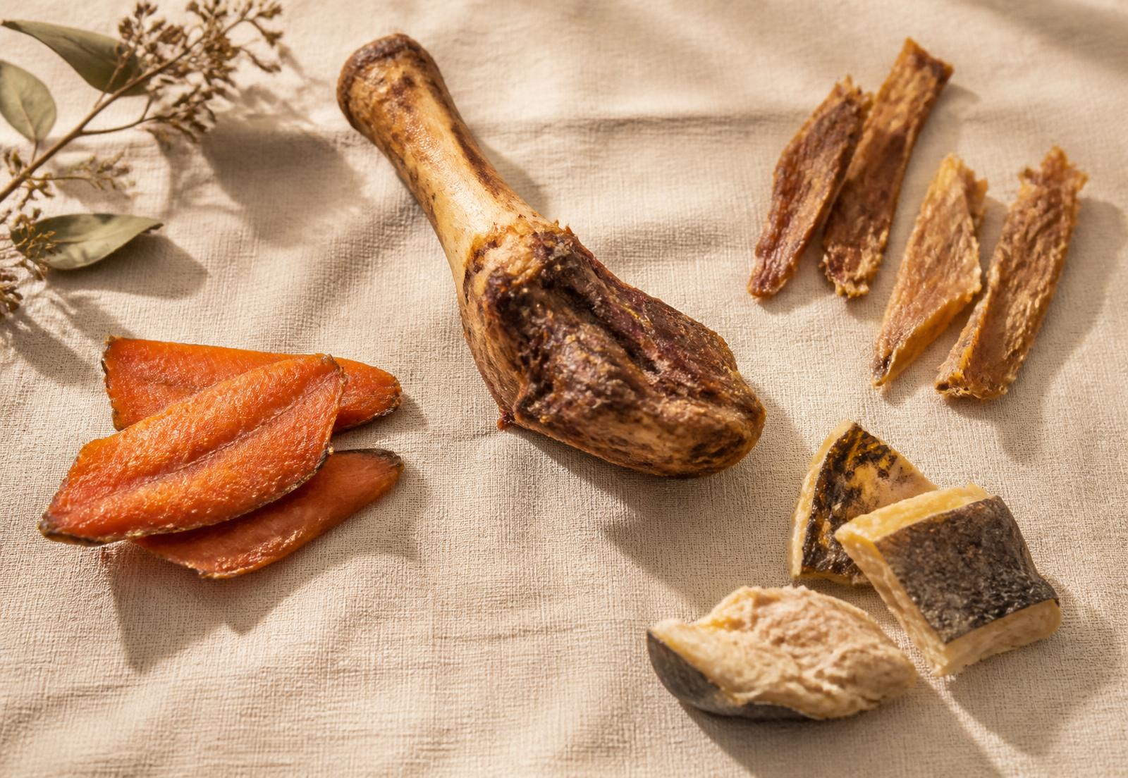 Dehydrated salmon, chicken strips, cod and a whole lamb shank laid out on linen